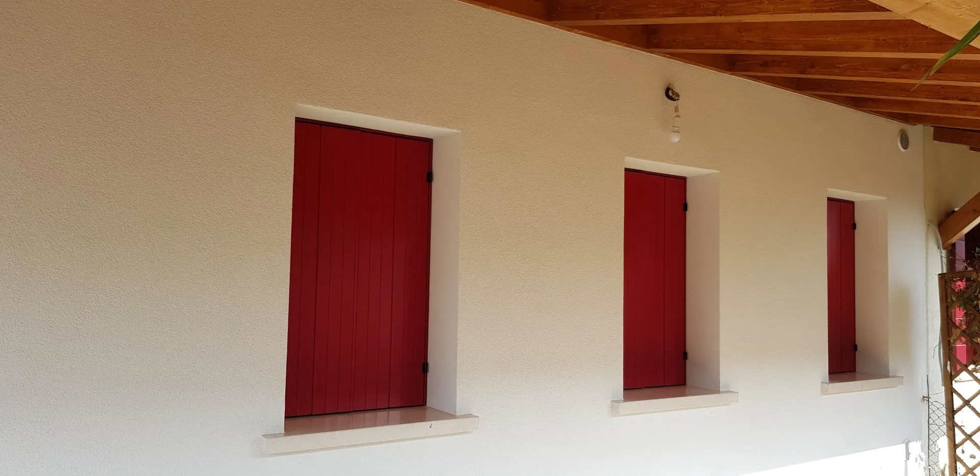 Scuri rossi su una casa bianca con portico